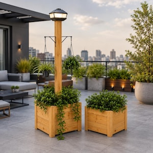Op de afbeelding: Een hoge houten plantenbak met een geïntegreerde verticale paal voorzien van een lantaarn op zonne-energie aan de bovenkant en twee metalen armen voor hangplanten, vergezeld door een kleinere bijpassende vierkante houten plantenbak, beide gevuld met groen.