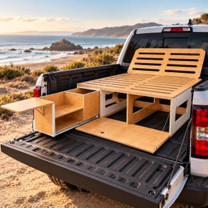 May include: A light-coloured wooden truck bed camper platform system featuring a slatted bed frame, a pull-out storage drawer unit with an integrated side table, and a flat base panel, all installed within the open cargo bed of a white pickup truck.