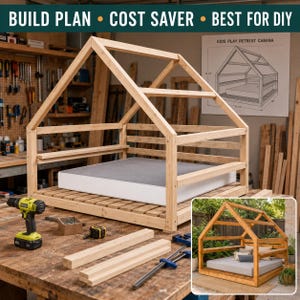 May include: A wooden house-shaped bed frame with a gabled roof design, featuring a slatted base and a gray mattress. The frame is displayed in a workshop setting with tools and a printed build plan titled Kids Play Retreat Cabana visible.