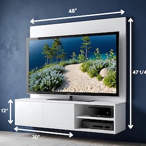 Pode incluir: Um móvel de entretenimento branco montado na parede com uma moldura de 122 cm de largura e um armário de 76 cm de largura. A unidade inclui uma moldura de 120 cm de altura, uma TV e armazenamento para dispositivos de mídia. A TV exibe uma paisagem.
