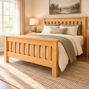 Puede incluir: Una estructura de cama de madera de tono claro con cabecero y piecero de listones. La cama está vestida con sábanas blancas, una manta de color verde oliva con textura y varios cojines, incluido uno rectangular central a rayas.