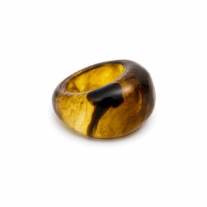 May include: A chunky ring crafted from translucent amber-colored resin, featuring swirling patterns of dark brown and golden yellow throughout the material. The band has a smooth, rounded, and polished surface with a thick, solid construction.