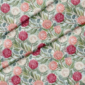Puede incluir: Un patrón de tela que presenta una ilustración repetitiva en acuarela de flores de protea en tonos magenta intenso, rosa suave y blanco, intercaladas con hojas verdes y tallos marrones finos sobre un fondo azul pálido.