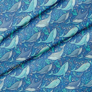 Può includere: Un motivo in tessuto con un'illustrazione ripetuta di balene e narvali in tonalità di blu, verde acqua e verde. Il design include intricate linee vorticose e motivi di alghe su uno sfondo blu intenso, creando una densa scena sottomarina.