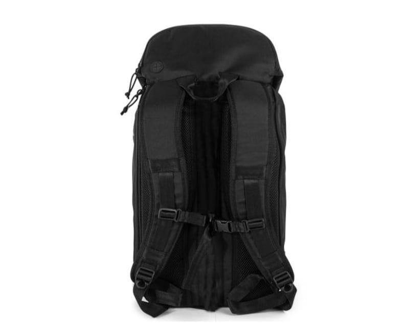 May include: Black backpack with adjustable shoulder straps, a top handle, and multiple compartments. The backpack features a zippered closure and a padded back panel for comfort. The design includes multiple buckles and straps for securing items. The bag is made of a durable, water-resistant material.