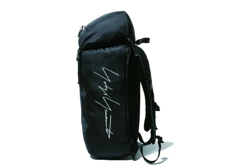 May include: Black backpack with a curved top and a zippered main compartment. The bag features a white script logo on the front and adjustable shoulder straps. The backpack is made of a durable material and is suitable for carrying various items.