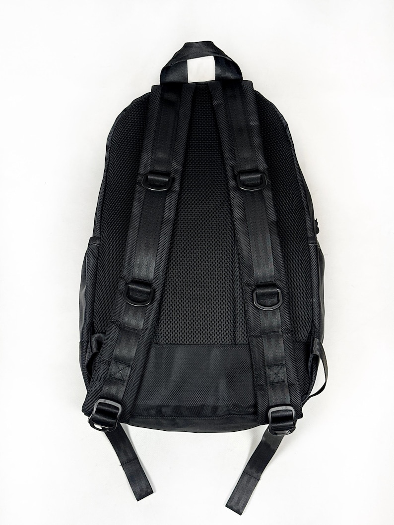 Peut inclure: Un sac &agrave; dos noir dot&eacute; de bretelles r&eacute;glables avec anneaux en D int&eacute;gr&eacute;s, d'une poign&eacute;e de transport sup&eacute;rieure et d'un panneau arri&egrave;re en maille respirante. Le design pr&eacute;sente des coutures renforc&eacute;es sur les bretelles et une finition ext&eacute;rieure noire.