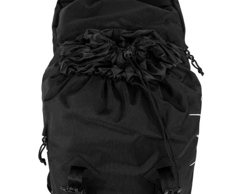 May include: Black backpack with a drawstring closure at the top. The backpack has adjustable straps and buckles. The material appears to be a durable, textured fabric. The design is minimalist and functional, suitable for various outdoor activities.