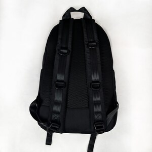 Puede incluir: Una mochila negra con panel trasero de malla acolchada, correas ajustables para los hombros con anillas en D integradas y un asa superior. El dise&ntilde;o incluye costuras reforzadas en las correas y un exterior de tela negra estructurada.