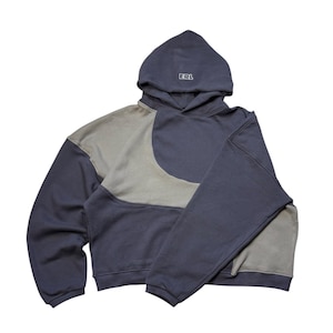 Può includere: Una felpa con cappuccio a blocchi di colore blu navy e grigio con cappuccio con coulisse. La felpa con cappuccio presenta le lettere "ERL" ricamate sul cappuccio. Il design include un esclusivo stile patchwork con pannelli a contrasto grigi e blu navy.