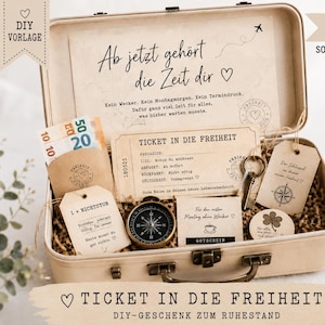 Könnte beinhalten: Ein beigefarbener Koffer im Vintage-Stil, gefüllt mit Geschenkartikeln aus Papier, darunter ein Ticket mit der Aufschrift Ticket in die Freiheit, ein Kompass, ein Metallschlüssel, Papieranhänger mit deutschem Text und Euro-Banknoten. Der Kofferdeckel trägt den Text Ab jetzt gehört die Zeit dir.