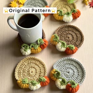Puede incluir: Cinco posavasos circulares de ganchillo en gris, beige y marrón, cada uno con una fila de pequeñas calabazas rellenas en naranja, amarillo y blanco con tallos verdes. Una taza blanca con café negro descansa sobre uno. El texto dice Original Pattern.