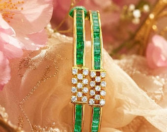 May include: Two gold bangles featuring a channel setting of rectangular green emeralds and a central rectangular cluster of round white diamonds. The bracelets are constructed with a polished gold metal frame, showcasing a vibrant green and clear stone contrast.
