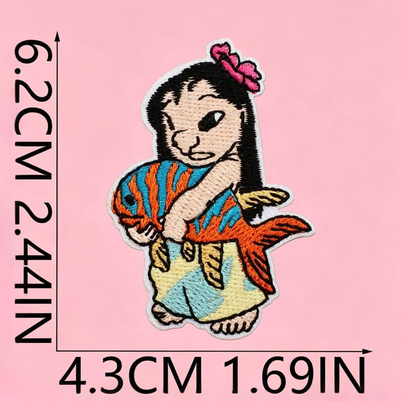 Op de afbeelding: Een geborduurde patch met een figuur met zwart haar en een roze bloem, die een grote oranje vis met blauwe strepen vasthoudt. De patch meet 6,2 cm bij 4,3 cm, of 2,44 inch bij 1,69 inch, en bevat een lichtblauwe en gele rok.