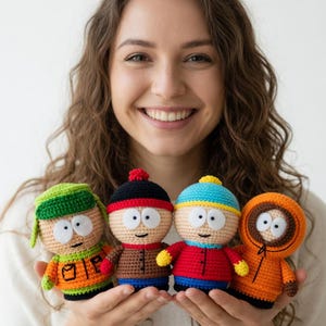 Puede incluir: Cuatro muñecos de ganchillo hechos a mano, cada uno representando a un personaje de la serie animada South Park. Los muñecos presentan atuendos y expresiones faciales distintivas, con colores como naranja, rojo, azul y verde. Los muñecos se sostienen frente a un fondo blanco.