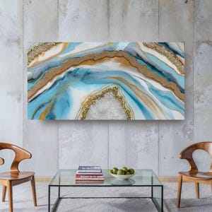 Könnte beinhalten: Abstrakte Wandkunst mit einem Geoden-Design in Blau, Weiß und Gold. Das Kunstwerk hat eine strukturierte Optik mit Glitzerakzenten, die eine luxuriöse Ästhetik erzeugt. Das rechteckige Stück ist an einer neutralen Wand befestigt.