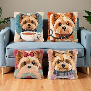Op de afbeelding: Vier vierkante kussens met getextureerde punch needle ontwerpen van Yorkshire Terriers. Links-boven een hond met een koffiekop, rechts-boven met een riem, links-onder met een rode strik en rechts-onder met een sjaal afgebeeld.