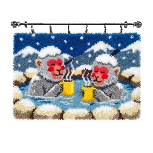 May include: A rectangular punch needle wall hanging featuring two grey monkeys with red faces soaking in a blue hot spring. Each monkey holds a yellow mug with steam rising. The background shows snow-covered mountains under a dark blue sky.