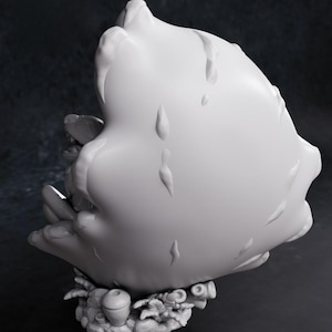 May include: A white, stylized sculpture with a textured surface and a base featuring small, detailed elements. The sculpture has a rounded shape with droplet-like details. The words "CHIBI TURNTABLE" are visible in orange.