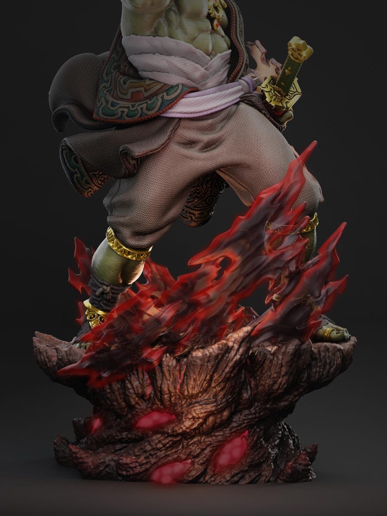 May include: A detailed figurine of a warrior figure, with green skin and ornate gold accents. The figure is posed above a base of fiery red and brown elements, holding a golden sword. The warrior is dressed in brown and white clothing with decorative patterns.