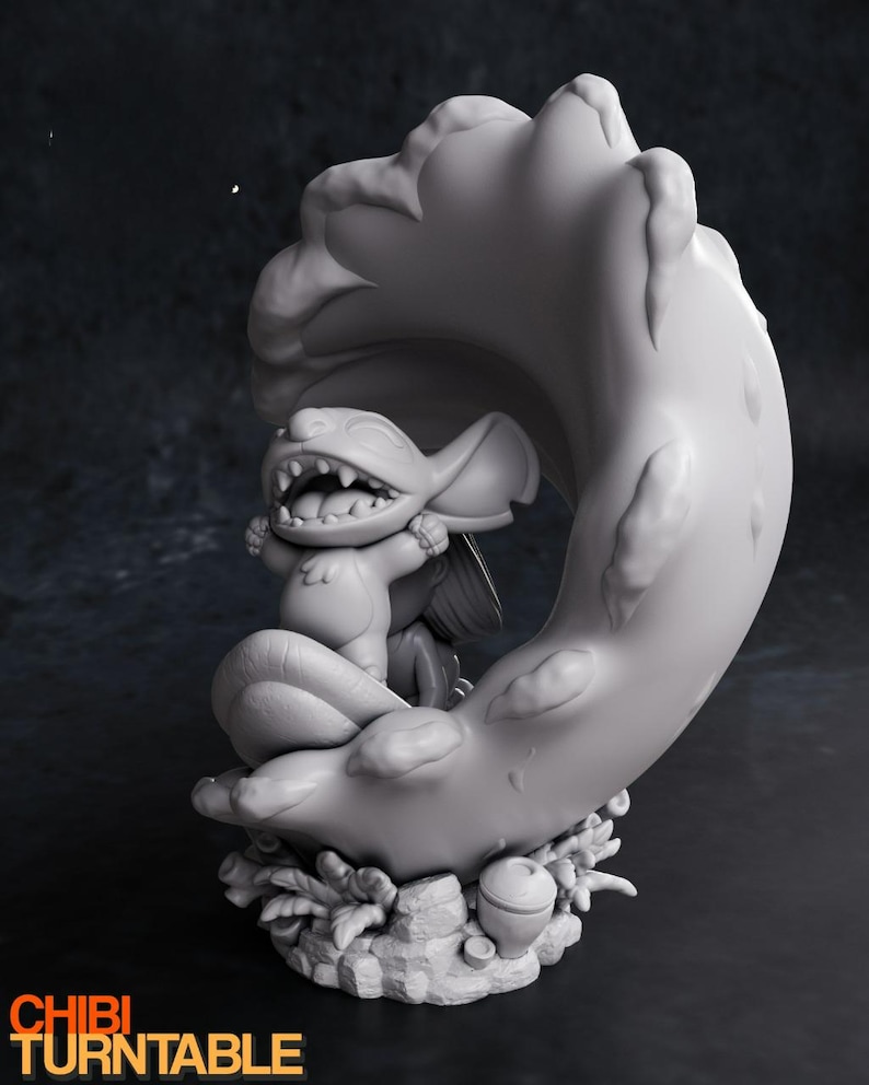 May include: A gray figurine of a cartoon character with large ears and a wide grin, seated on a crescent moon-shaped structure. The base features foliage and an acorn. The text "CHIBI TURNTABLE" is at the bottom.