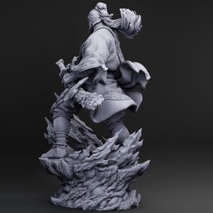 May include: A detailed, gray figurine of a warrior in traditional garb, holding a sword. The figure is posed dynamically atop a textured, rocky base. The warrior's hair is styled in a topknot, and the clothing features intricate details.