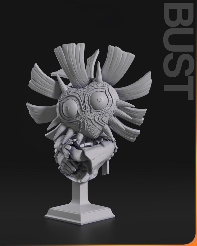 May include: A gray bust of a mask with large eyes, a detailed face, and spiky protrusions. The mask is mounted on a square pedestal. The word "BUST" is printed vertically on the right side of the image.