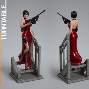 May include: A collectible figurine of a woman in a red dress holding a machine gun, standing on a gray metal staircase. The figurine has black hair and is wearing a black choker. The base of the figurine has the text "LOOTBOX TURNTABLE".