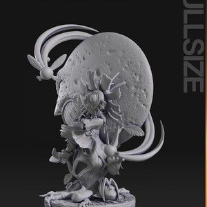 May include: A detailed, gray 3D-printed figurine of a whimsical creature. The figure has a large, textured head with a smiling face, adorned with leaf-like features and a fairy-like accessory. The base is circular, and the word "FULLSIZE" is printed on the side.