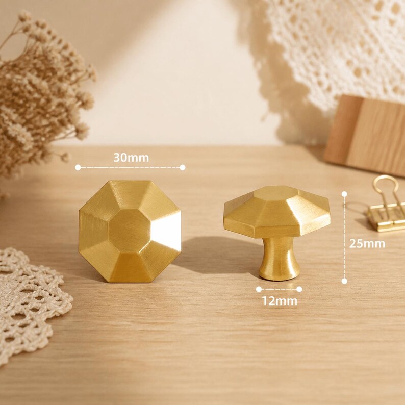 May include: Two gold-colored metal cabinet knobs with an octagonal faceted top. One knob is shown from the front, and the other is shown from the side. Dimensions are marked as 30mm in diameter, 25mm in height, and a 12mm base diameter.