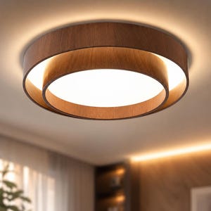 May include: A contemporary ceiling light featuring a circular design with a wood-effect finish. The light has a layered structure with a bright, white central light source. The fixture is mounted on a white ceiling.