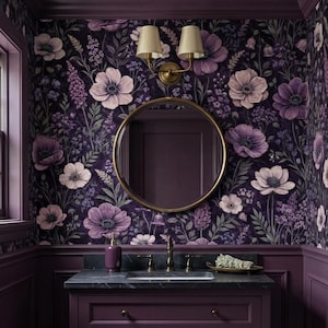 May include: A bathroom with a dark purple floral wallpaper featuring large anemone flowers in shades of purple and white. A round gold mirror hangs above a dark purple vanity with a black countertop. A gold sconce with two lamps is mounted on the wall.