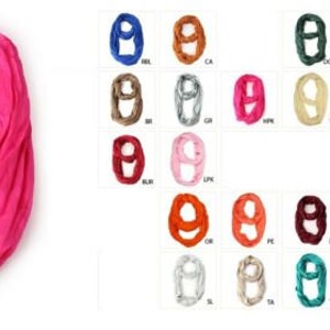 May include: A collection of 36 infinity scarves in various colors, including pink, blue, green, red, and white. The scarves are made of a soft, stretchy fabric and are perfect for adding a pop of color to any outfit.