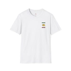 Op de afbeelding: Wit T-shirt met korte mouwen en een klein embleem op de borst. Het embleem toont een gele leeuw met een zwaard, een groene streep en een bordeauxrode streep. Het shirt heeft een ronde hals en een eenvoudig, strak ontwerp.