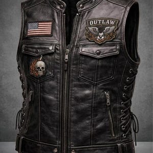 May include: Black leather vest with multiple pockets, zippers, and decorative patches. Features an American flag patch, an "OUTLAW" patch with an eagle and skull, and a skull with flames. The vest has a zip-up front and lace-up sides.