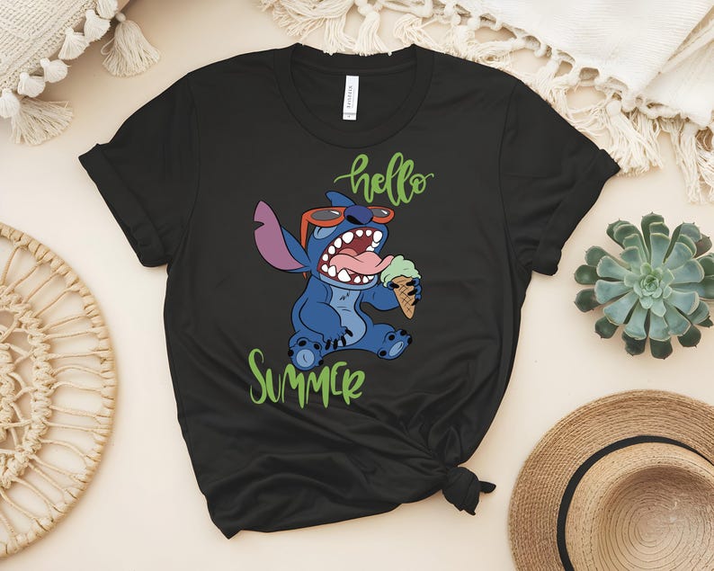 K&ouml;nnte beinhalten: Schwarzes T-Shirt mit einem Cartoon-Stitch-Design, das eine Sonnenbrille tr&auml;gt und Eis isst. Die Worte "hello summer" sind in gr&uuml;ner Schrift geschrieben. Das Design ist auf dem T-Shirt zentriert.