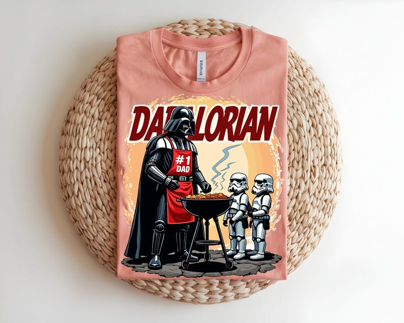 May include: A peach-coloured t-shirt with a graphic of Darth Vader grilling with Stormtroopers. The text "Darthlorian" is above the image. Darth Vader wears a red apron that says "#1 Dad".