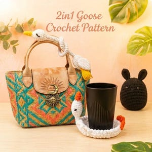 Peut inclure: Un affichage de texte 2in1 Goose Crochet Pattern avec un sac à main tissé doté d'un fermoir soleil et lune, une oie crochetée blanche sur la poignée, un gobelet noir, un dessous de verre oie crocheté blanc et une petite figurine ronde crochetée noire.