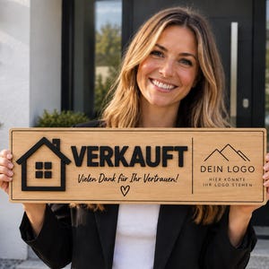 Könnte beinhalten: Ein rechteckiges Holzschild mit einem schwarzen Haus-Symbol, dem Wort VERKAUFT, dem Text Vielen Dank für Ihr Vertrauen, einem Herz-Symbol und einer Berggrafik mit dem Text DEIN LOGO HIER KÖNNTE IHR LOGO STEHEN in schwarzer Schrift.