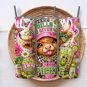 May include: Three cylindrical tumblers with black straws featuring a colorful graphic print of a Highland cow wearing a pink hat, surrounded by pickles, popcorn, flowers, butterflies, and the text ZERO DILLS GIVEN IN MY PICKLE ERA.