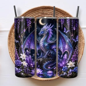Könnte beinhalten: Ein zylindrischer Becher mit schwarzem Strohhalm, verziert mit einer Illustration eines blau-violetten Drachen, einer Mondsichel, leuchtenden Kristallen und Blumen. Das Design zeigt violette Rosen, weiße Lilien und Schmetterlinge vor einem dunklen Waldhintergrund.