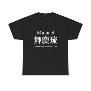 以下が含まれることがあります： 胸元に白いテキストがプリントされた黒の半袖Tシャツ。デザインには「Michael」という名前、3つの日本語の漢字、そして中央に配置されたサンセリフフォントの「Celebration • Brilliance • Flow」という言葉が含まれています。