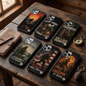 May include: Six black smartphone cases featuring Sasquatch illustrations. Designs include a sunset silhouette, a campfire scene with text 'CAMP MORE WORRY LESS', a forest scene with 'SASQUATCH HIDE & SEEK CHAMPION', a fishing scene, an American flag, and a Halloween theme.