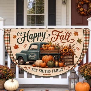 Op de afbeelding: Een halfrond houten bord met de tekst Happy Fall en The Smiths Family. Het ontwerp bevat een blauwgroene vintage truck, oranje pompoenen, zonnebloemen en een lantaarn. De rand heeft een ruitpatroon in oranje, groen en wit.