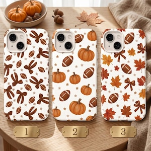 May include: Three white smartphone cases featuring autumn-themed patterns. Case 1 displays brown bows and footballs. Case 2 shows orange pumpkins and footballs. Case 3 features orange and brown maple leaves, bows, and footballs. Each case has a camera cutout.