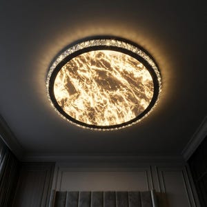 May include: A circular ceiling light with a black surround and a marble-effect centre. The outer edge is adorned with small crystals. The light emits a warm, golden glow, lighting the ceiling and the room below.