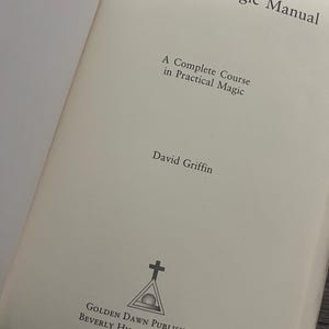 May include: Open book titled "The Ritual Magic Manual" by David Griffin. The book's cover features the text "A Complete Course in Practical Magic." The Golden Dawn Publishing logo is at the bottom, with locations Beverly Hills and Stockholm.