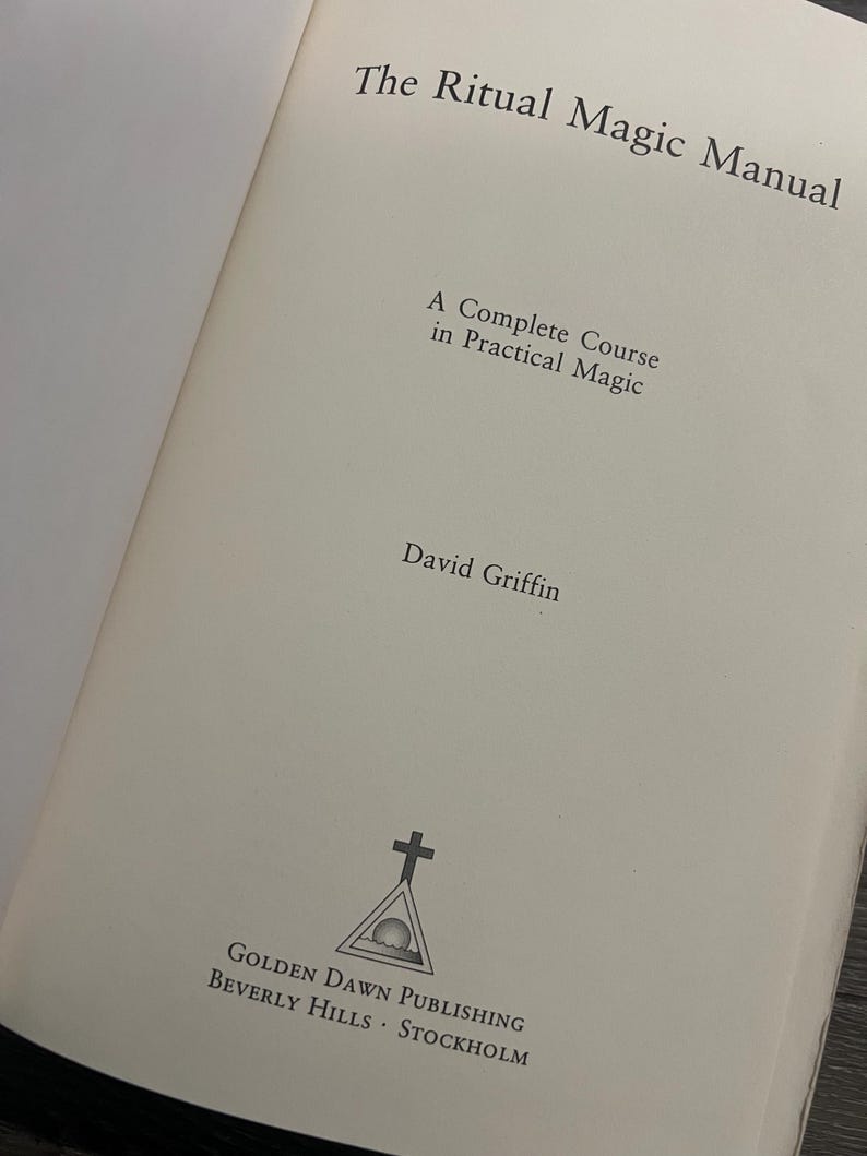May include: Open book titled "The Ritual Magic Manual" by David Griffin. The book's cover features the text "A Complete Course in Practical Magic." The Golden Dawn Publishing logo is at the bottom, with locations Beverly Hills and Stockholm.