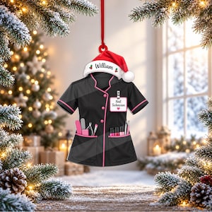 May include: A black and pink nail technician uniform ornament featuring a red Santa hat with the name William printed on the white brim. The uniform includes a white name tag labeled Nail Technician and pockets filled with various nail tools.