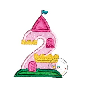 May include: An embroidered patch in the shape of the number two, designed as a pink castle with a dark pink roof, a teal flag, yellow battlements, and a green base. The patch features a small pink door and window, with a circular logo overlay.